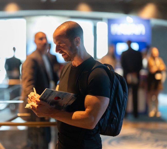 Todd Kashdan signing a copy of The Art of Insubordination for a reader